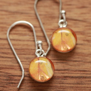 Tiny orange feather earrings made from recycled Starbucks gift cards, sterling silver and resin